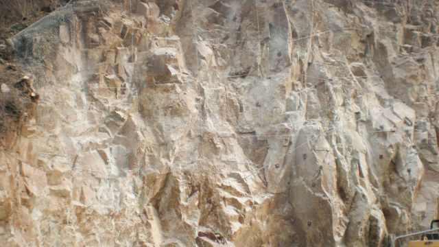 Absicherung der Felsböschungen bergseitig der Baustellenfläche mittels Metallgitternetzen verstärkt mit Stahlseilen und Verankerungen mittels Felsnägel. Völser Aicha (BZ), 2017. Absicherung der Felsböschungen bergseitig der Baustellenfläche mittels Metallgitternetzen verstärkt mit Stahlseilen und Verankerungen mittels Felsnägel. Völser Aicha (BZ), 2017.